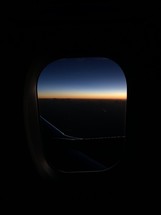 view out of a plane window at dawn 