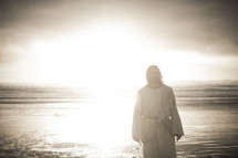 Jesus standing on a shore in bright sunlight 