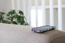 cellphone on a couch arm 