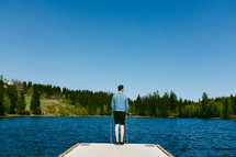 a man standing at the end of a dock