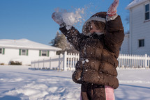 a little girl playing in snow 