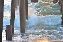 ocean waves under a pier 