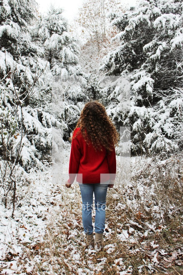 a woman standing in a forest in winter 