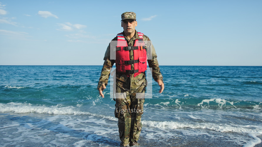 Military usa man training jumping jack in the shore near the ocean