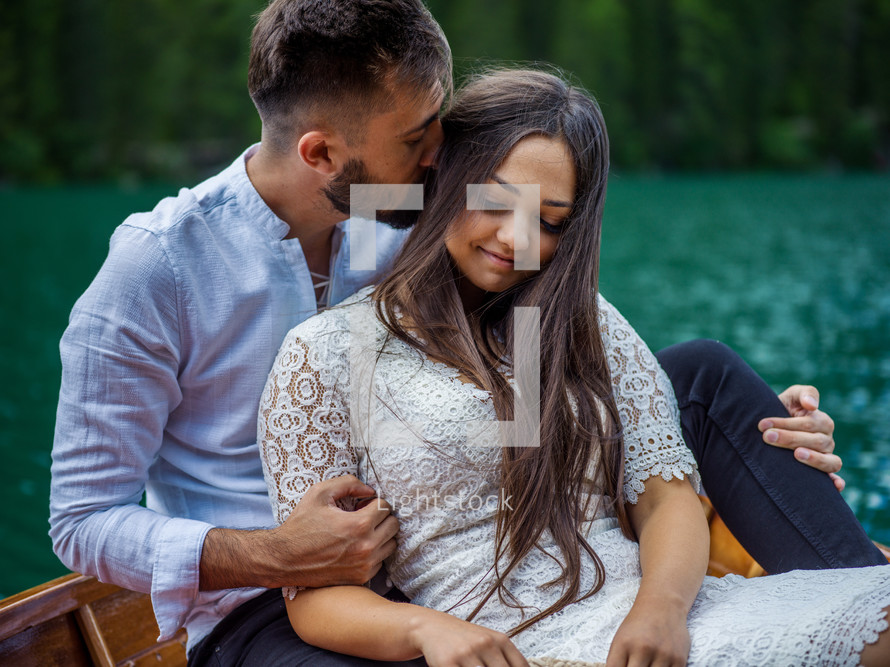 a couple cuddling on a rowboat 