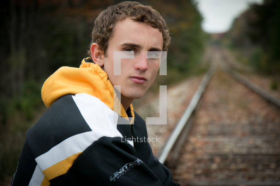 man sitting near railroad tracks 