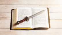 sword on the pages of a Bible 