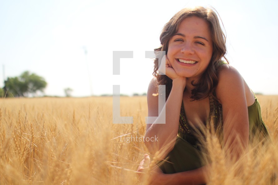 a young woman in a field of golden wheat 