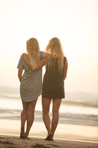 best friends standing together on a beach 