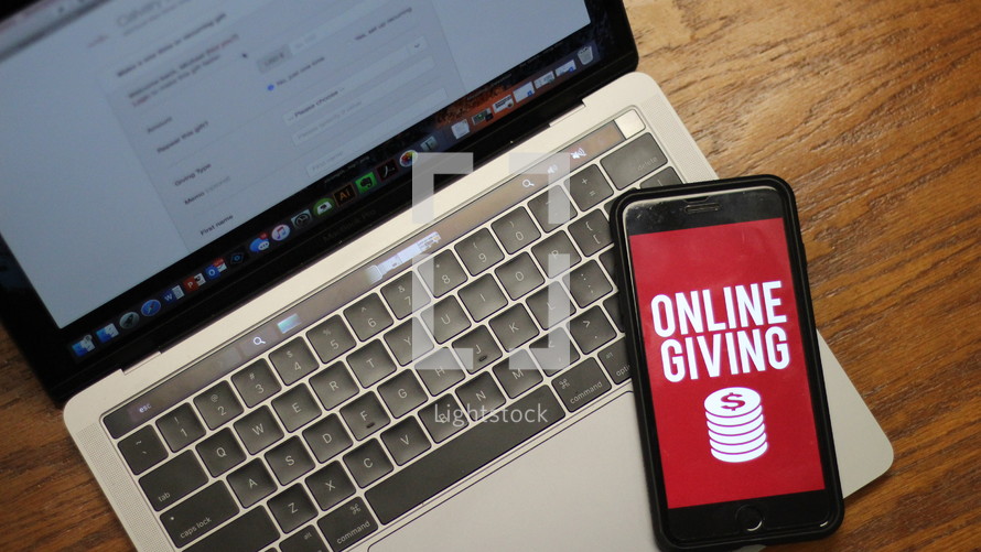 cellphone with online giving app on a laptop computer 