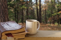 Bible and coffee mug on a railing 