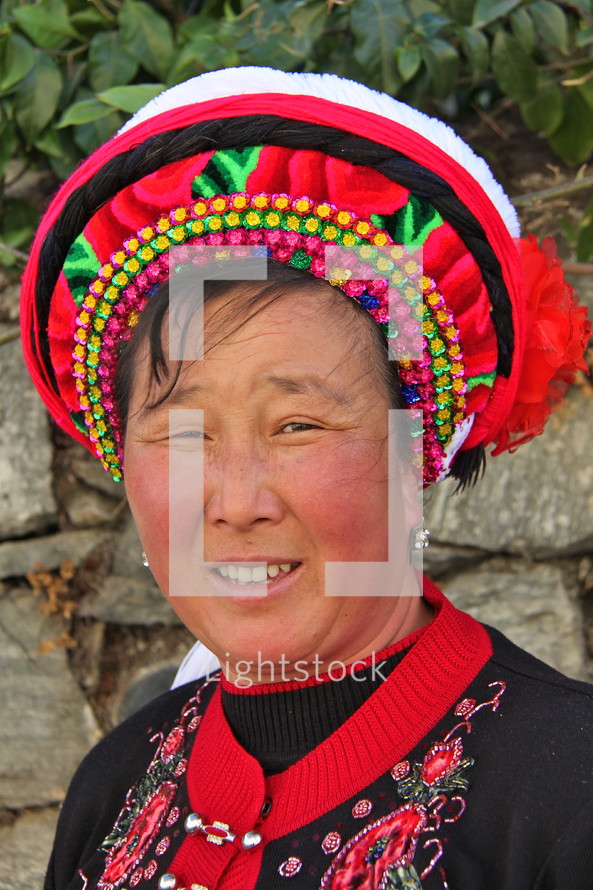 Smiling woman in a traditional hat from a minority tribe in China