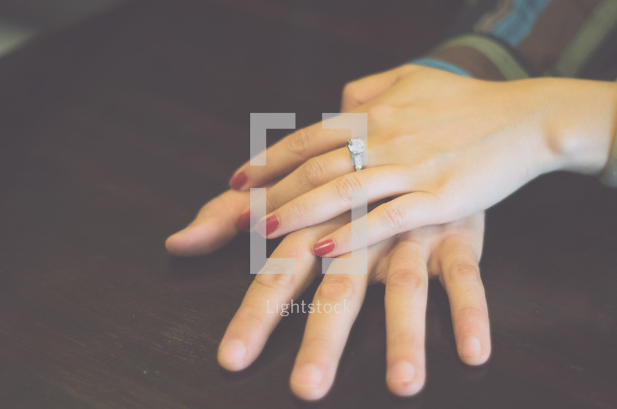 a woman's hands showing off her new engagement ring 
