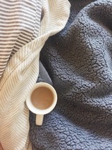 coffee mug on blankets 