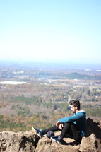 a man resting on a mountaintop 