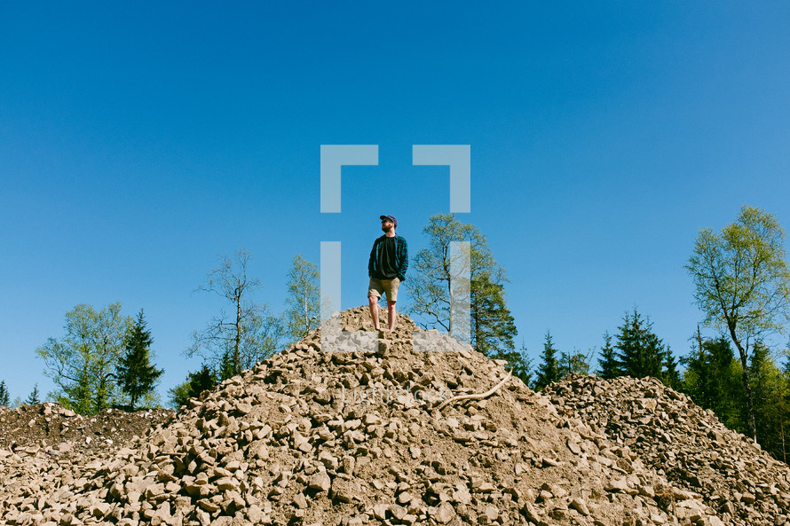 a man standing on a pile of rocks 