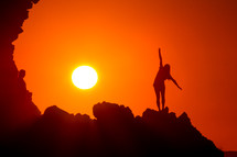 woman stretching on a mountain at sunset 