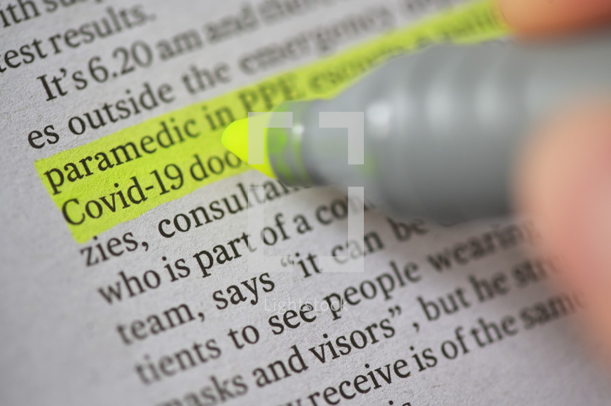 A Highlighter Marker on newspaper News about coronavirus disease COVID 19