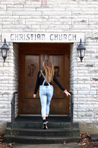 a young woman entering a church 