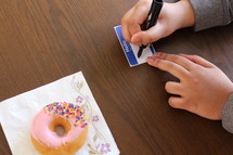 writing a name on a name tag and a donut on a napkin 