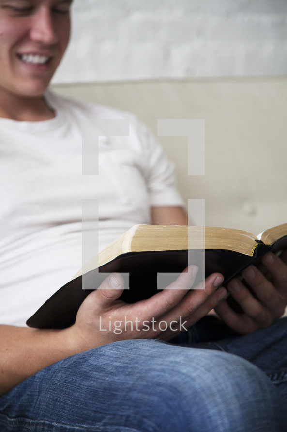 man reading a Bible smiling 