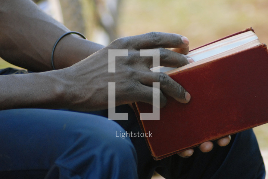 man resting holding a Bible 