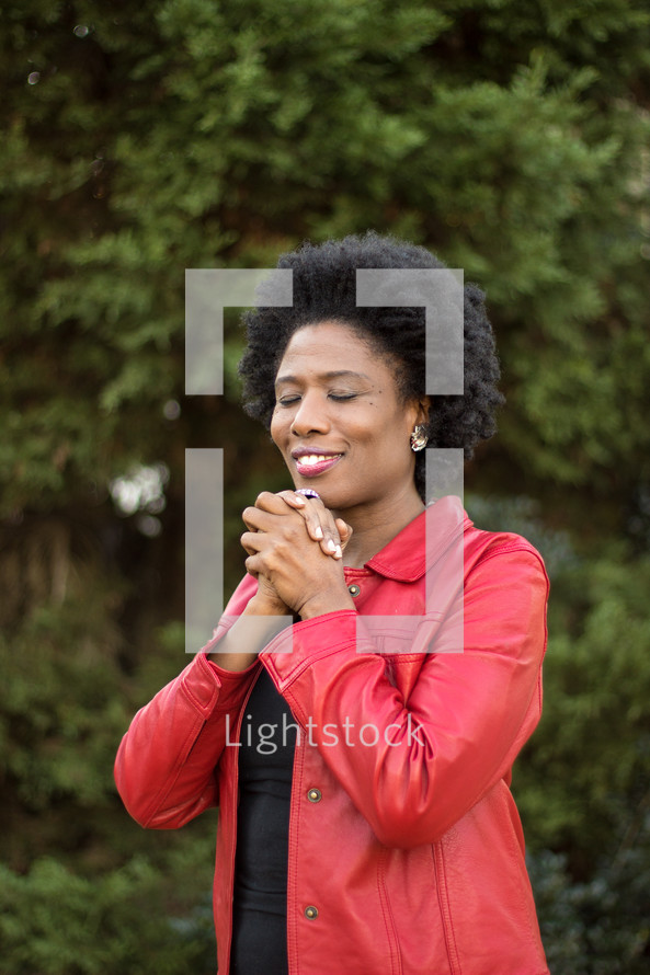 AN African American woman with praying hands 