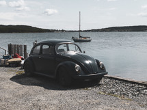 old Volkswagen Beetle parked on a shore 
