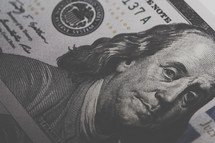 closeup of Benjamin Franklin on a one hundred dollar bill.