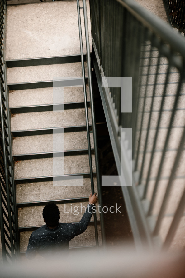 young man walking up steps outdoors 