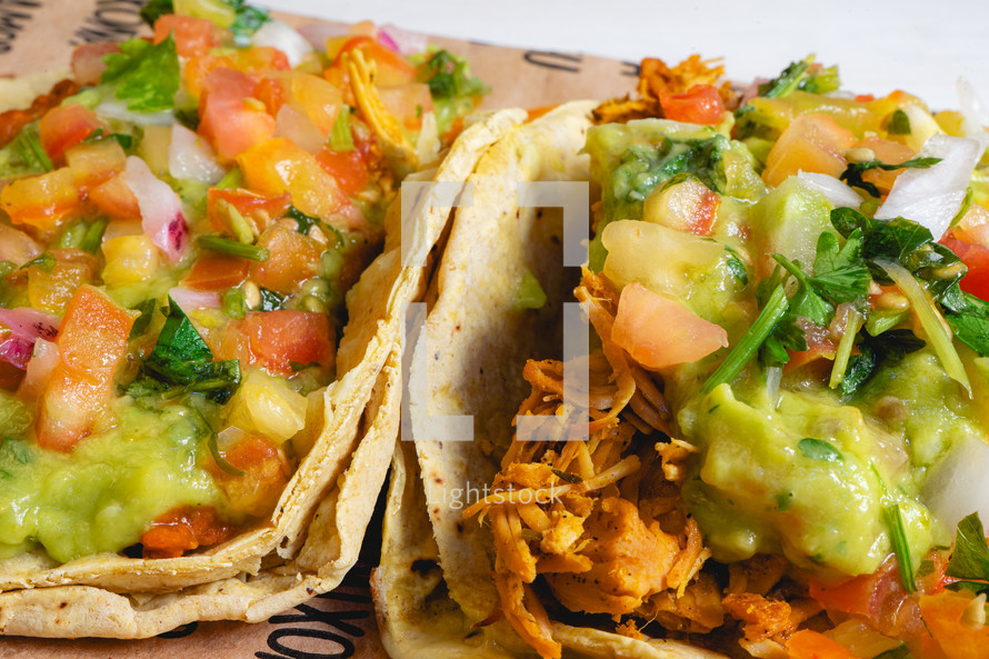 Two soft taco's with chicken and beans. laying down on brown paper. Mexican fastfood.