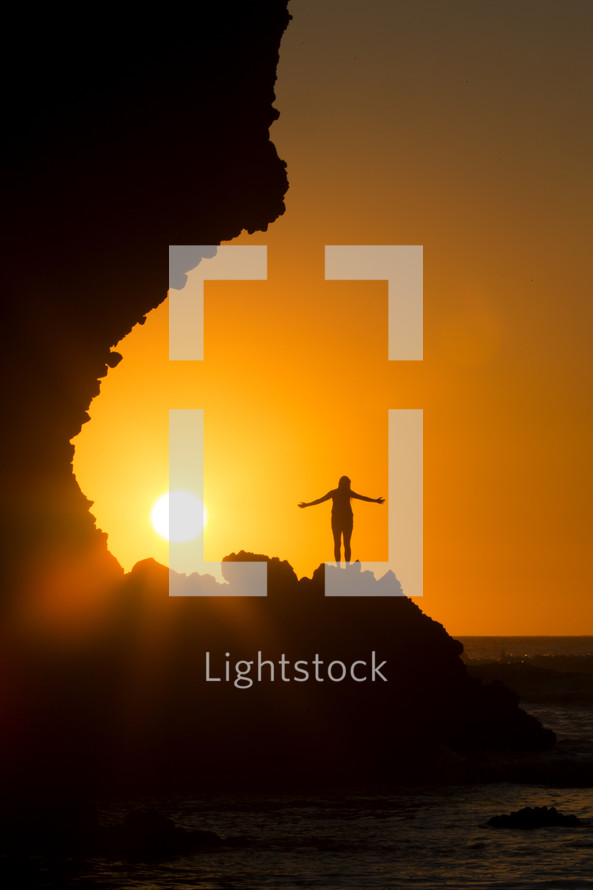 silhouette of a woman on a mountaintop at sunset 