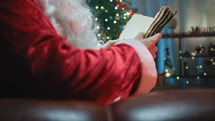 Santa Claus reading an old book on the sofa