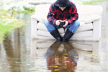 flood, man, sitting, couch, outdoors, water, coffee mug, wadding boots 