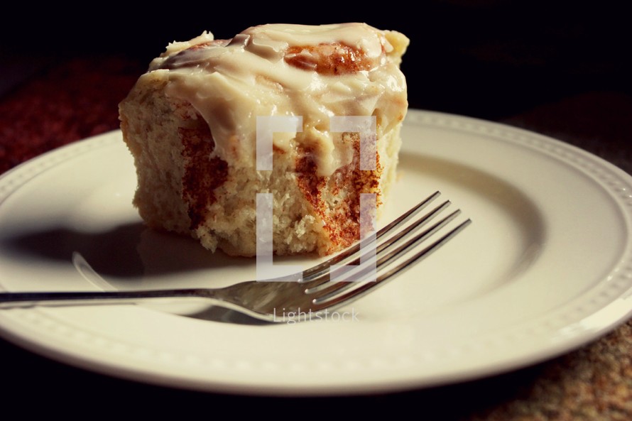 cinnamon roll on a plate with fork 
