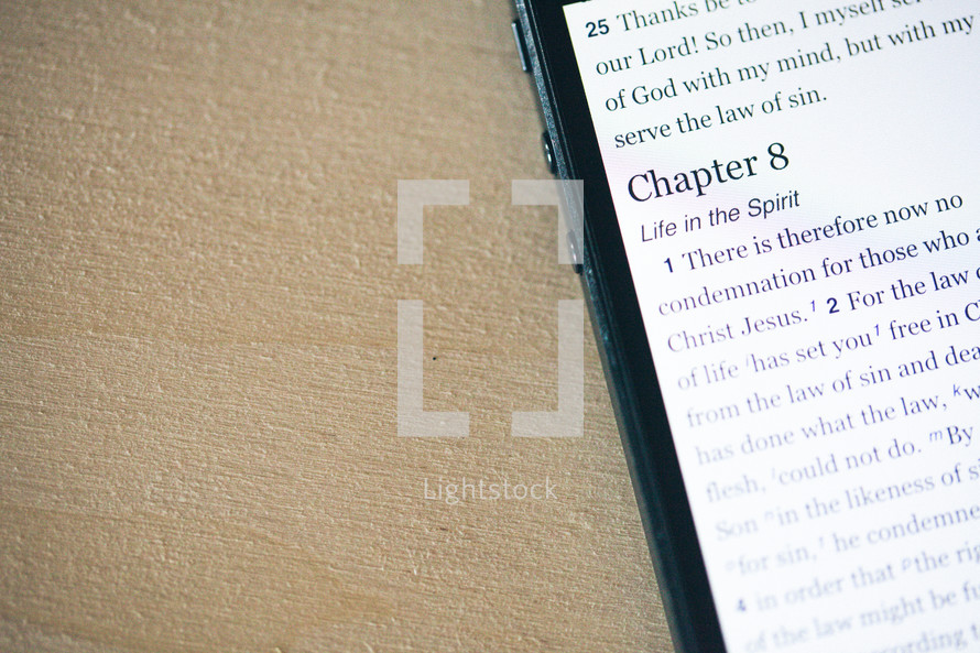 Romans 8 scripture on the screen of a smart phone.