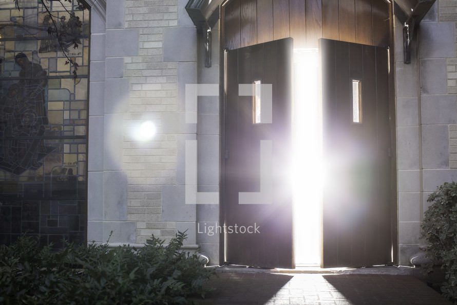 glow of sunlight and sunburst through an open door at church
