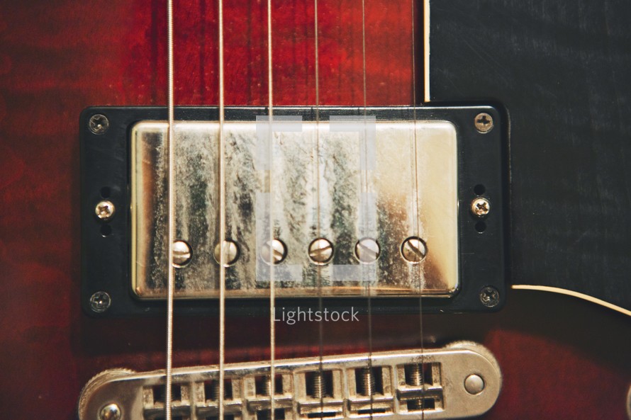 Close up of the bridge, saddle and strings of a guitar.