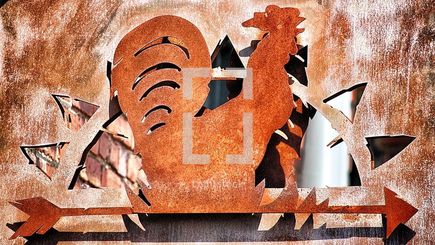 Rusted metal rooster sign.