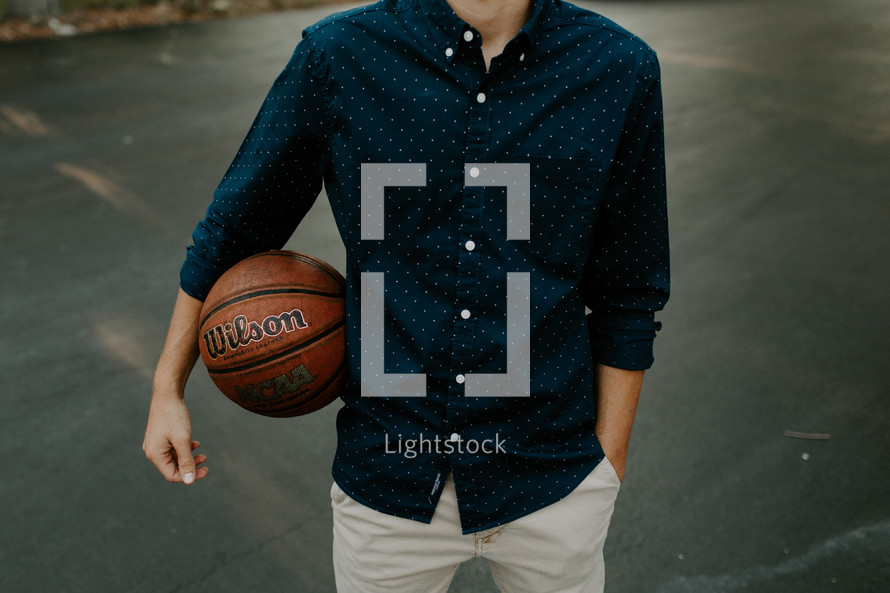 a young man holding a basketball 