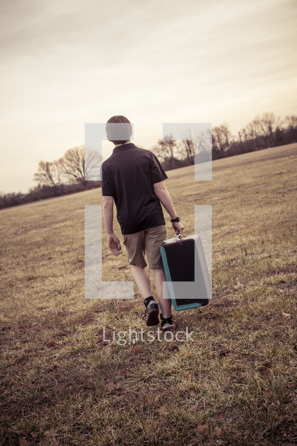 teen boy carrying an instrument case 