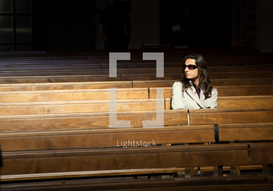 Woman praying in church and looks invisible presence to her right