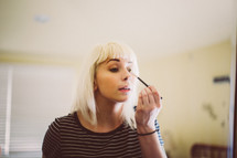 a woman putting on makeup 
