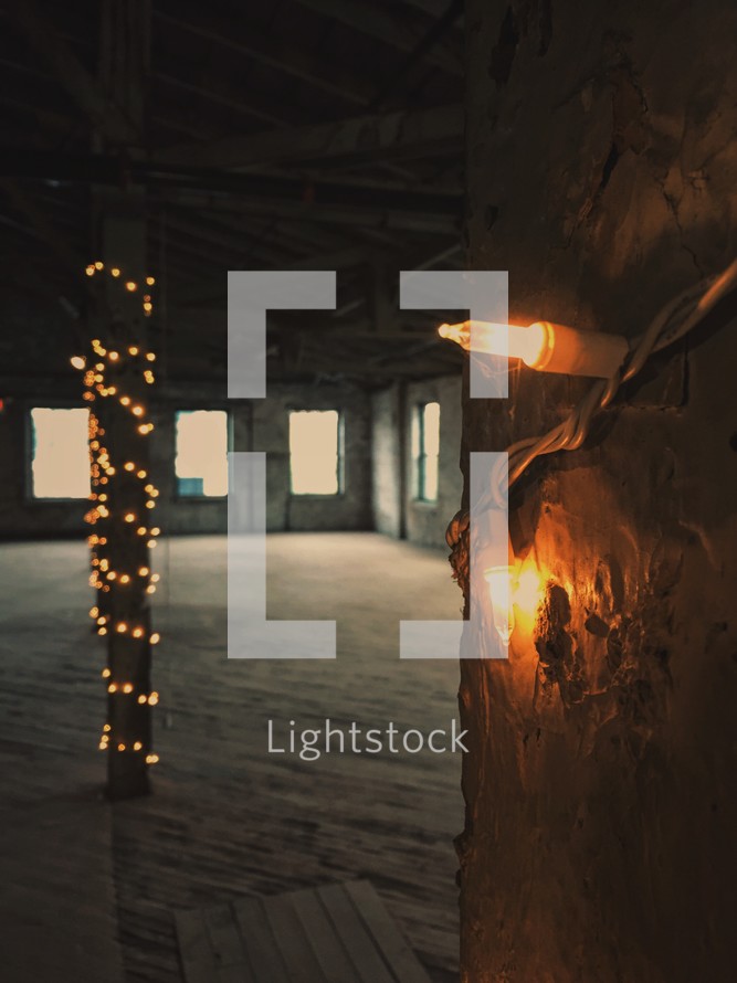 string of lights in an empty warehouse building 