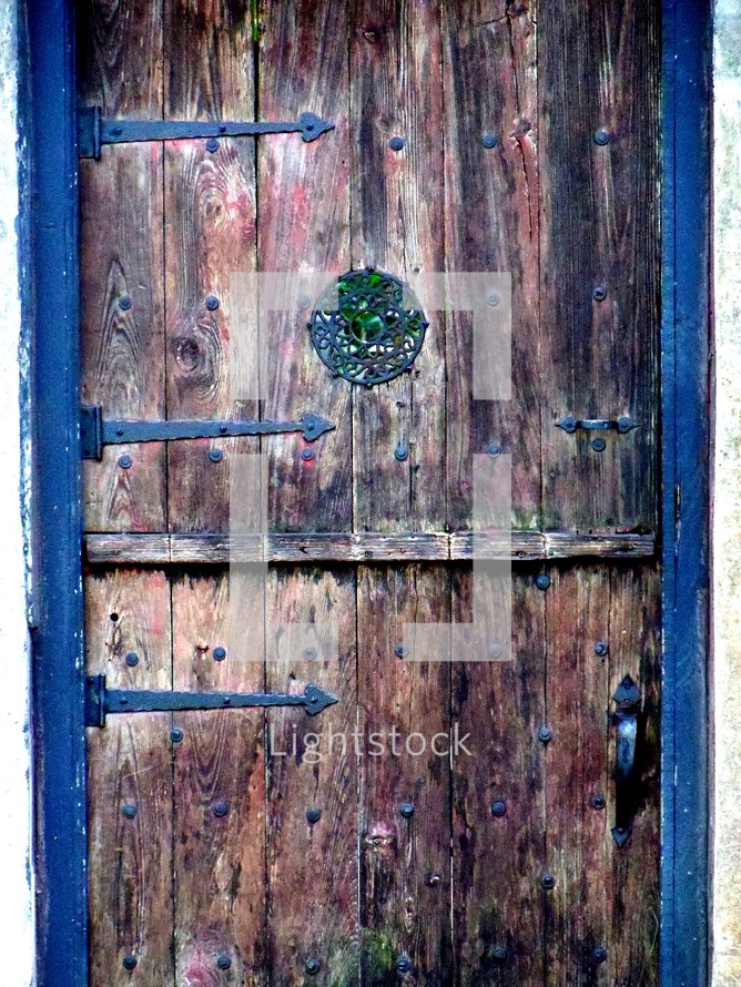 An old weather beaten wooden door framed with metal hinges. One cannot help but wonder what history this door has witnessed. I found this door to someone's home in historic Saint Augustine, Florida and just thought it had so much character and charm with its many colors and weathered exterior. 