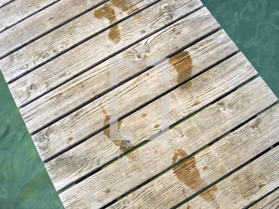 wet footprints on a dock 