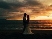bride and groom on a beach at sunset 