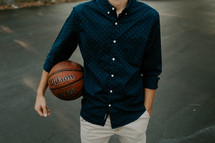 a young man holding a basketball 