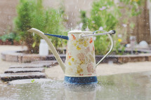 rain falling into a watering can