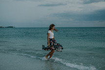 a young woman walking on a beach